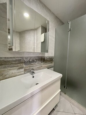 Studio supérieur (Apartma z 2 spalnicama, teraso pogled) | Salle de bain | Séchoir à cheveux, pantoufles, serviettes fournies, papier de toilette