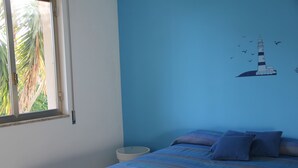 A bedroom with a bed, a window, and a wall mural of a lighthouse. - Apartment le Maschere (Marina di Modica)