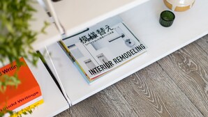 Un livre intitulé « RÉNOVATION D’INTÉRIEUR » est posé sur une étagère blanche.