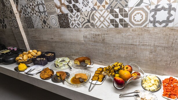 Una mesa de buffet con diversos alimentos, entre ellos frutas, verduras y postres.