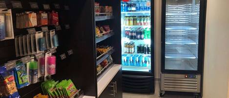 Zona de venta con aperitivos, bebidas y un refrigerador de Coca-Cola.
