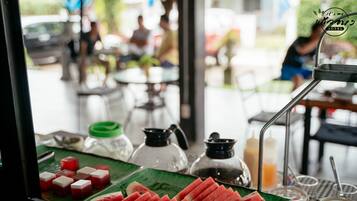 A table with sliced watermelon and a green plate, a coffee pot, and a water dispenser.