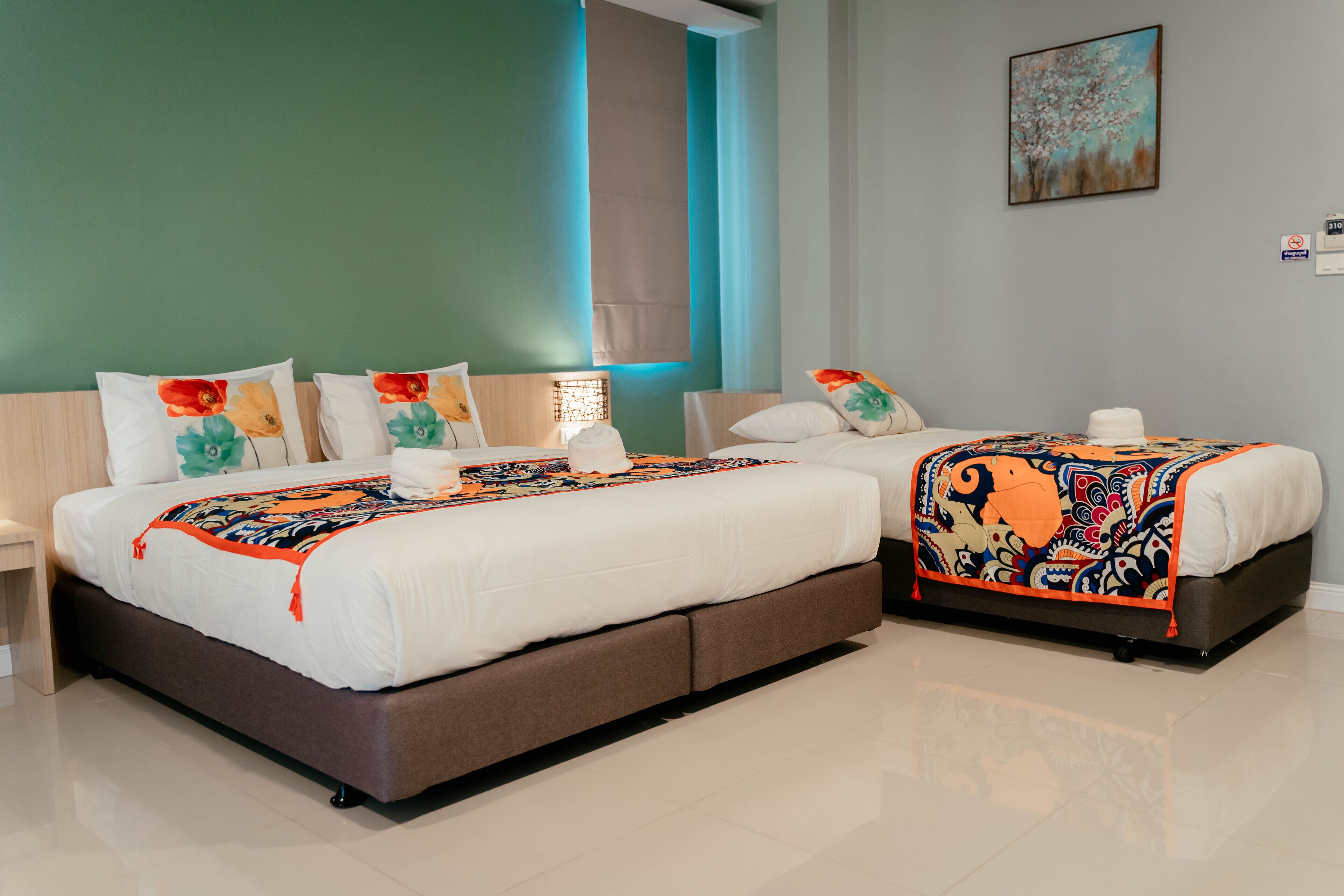 Una habitación de hotel moderna con una cama grande, dos mesitas de noche y un ventanal con cortinas.