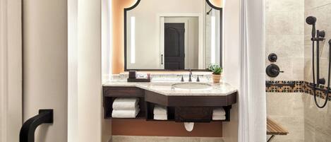 Une salle de bain avec un meuble-lavabo à deux vasques, un grand miroir, un espace douche et un plancher en bois.
