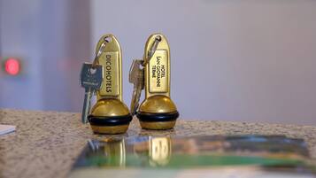 Two brass keychains with hotel names on a countertop.