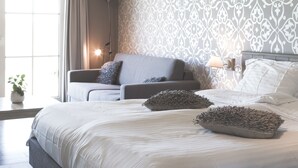 A modern bedroom with a large bed, two bedside tables, a floor lamp, and a window with curtains. - B&B Nieuwhof (Gistel)