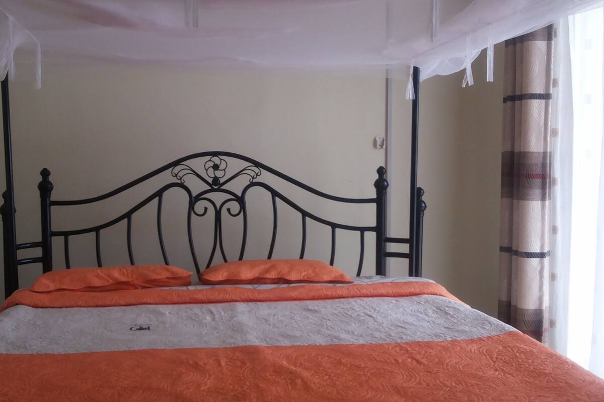 A bed with a headboard, a blanket, and pillows.