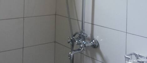Una ducha con cabezal de ducha de mano y grifo empotrado.