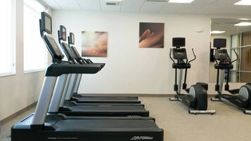 Un centre de remise en forme équipé de tapis de course, d’appareils elliptiques et de vélos d’appartement.