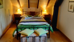 Une chambre à coucher avec un lit, deux tables de chevet et une petite table d’appoint.