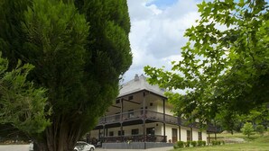 A two-story building with a balcony and a covered porch area. - Complejo O Piñeiral (Fonsagrada)