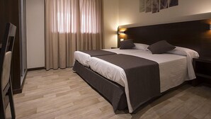 A hotel room with a large bed, a bedside table with a lamp, and a window with curtains. - Complejo O Piñeiral (Fonsagrada)