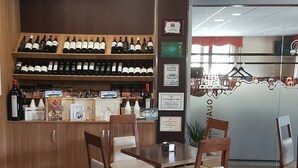 A restaurant interior with wooden furniture, a wine display, and framed certificates on the wall. - Complejo O Piñeiral (Fonsagrada)