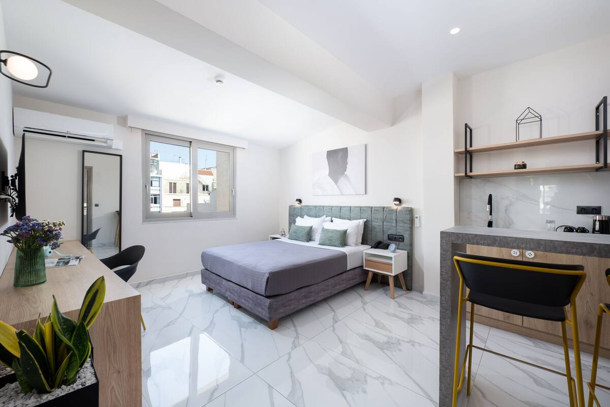 Une chambre à coucher moderne, avec un lit, des tables de chevet, un bureau et une chaise.