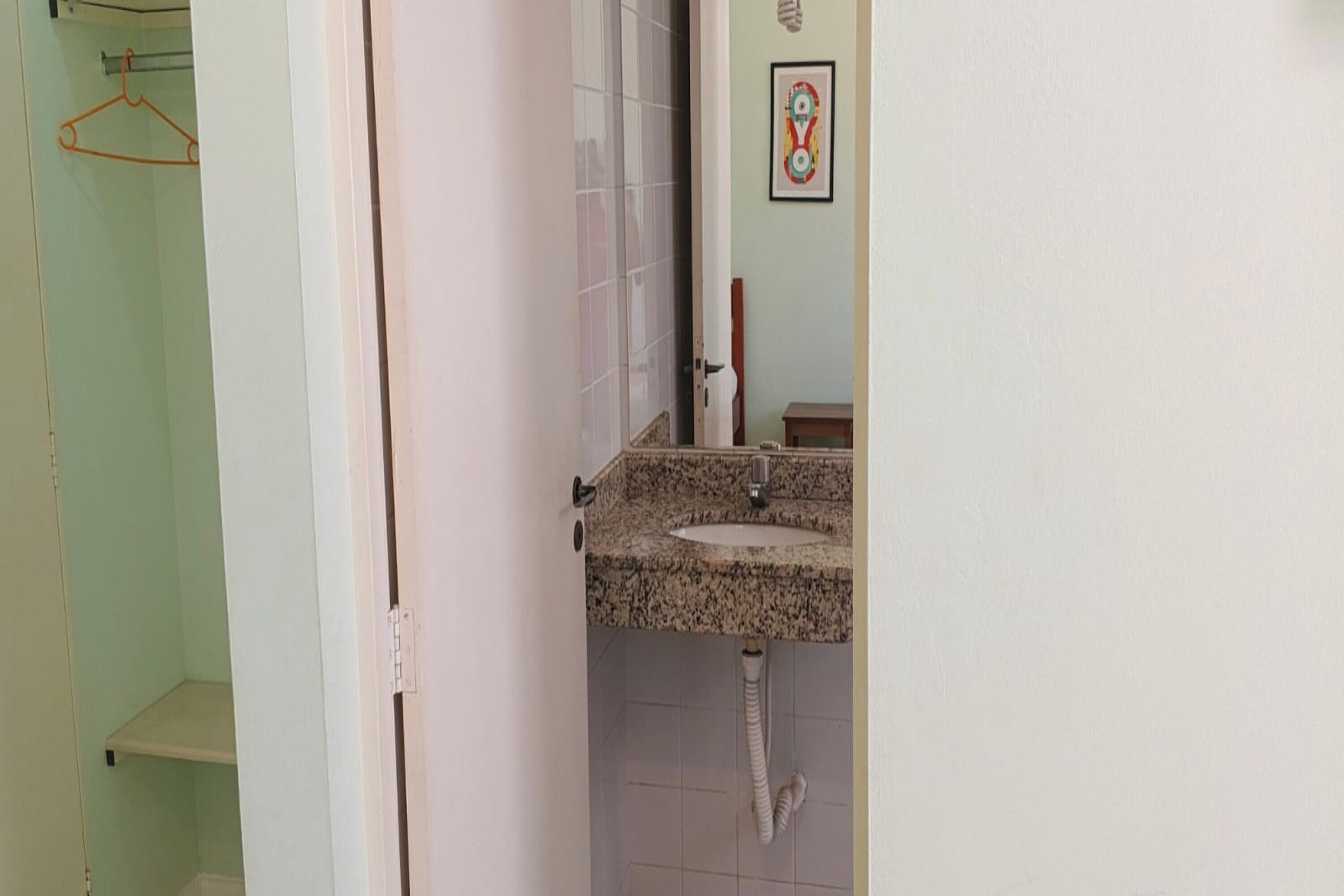 A bathroom with a granite countertop sink, a towel rack, and a framed picture on the wall.