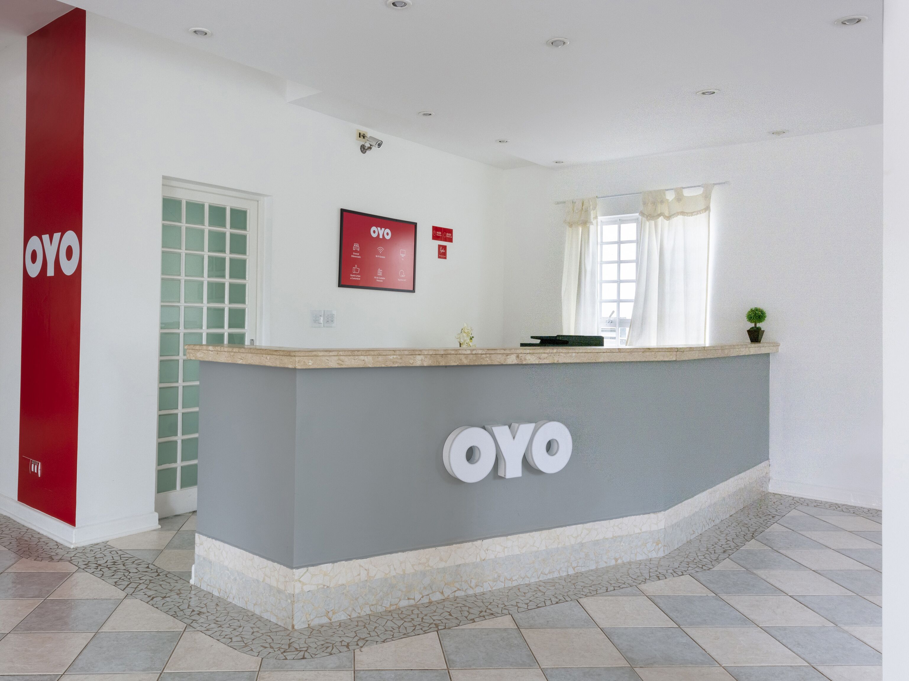 Zona de recepción con mostrador que muestra el logotipo “OYO”.