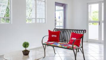 Quarto com um banco, uma mesa e um vaso de planta.
