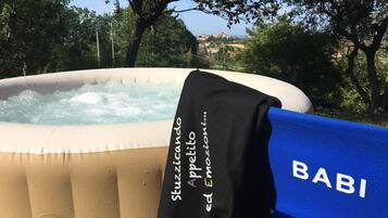 Ein aufblasbarer Whirlpool mit einem schwarzen Handtuch mit der Aufschrift "Stuzzicando Appetito ed Emozione" und einer blauen Matte mit "BABI".