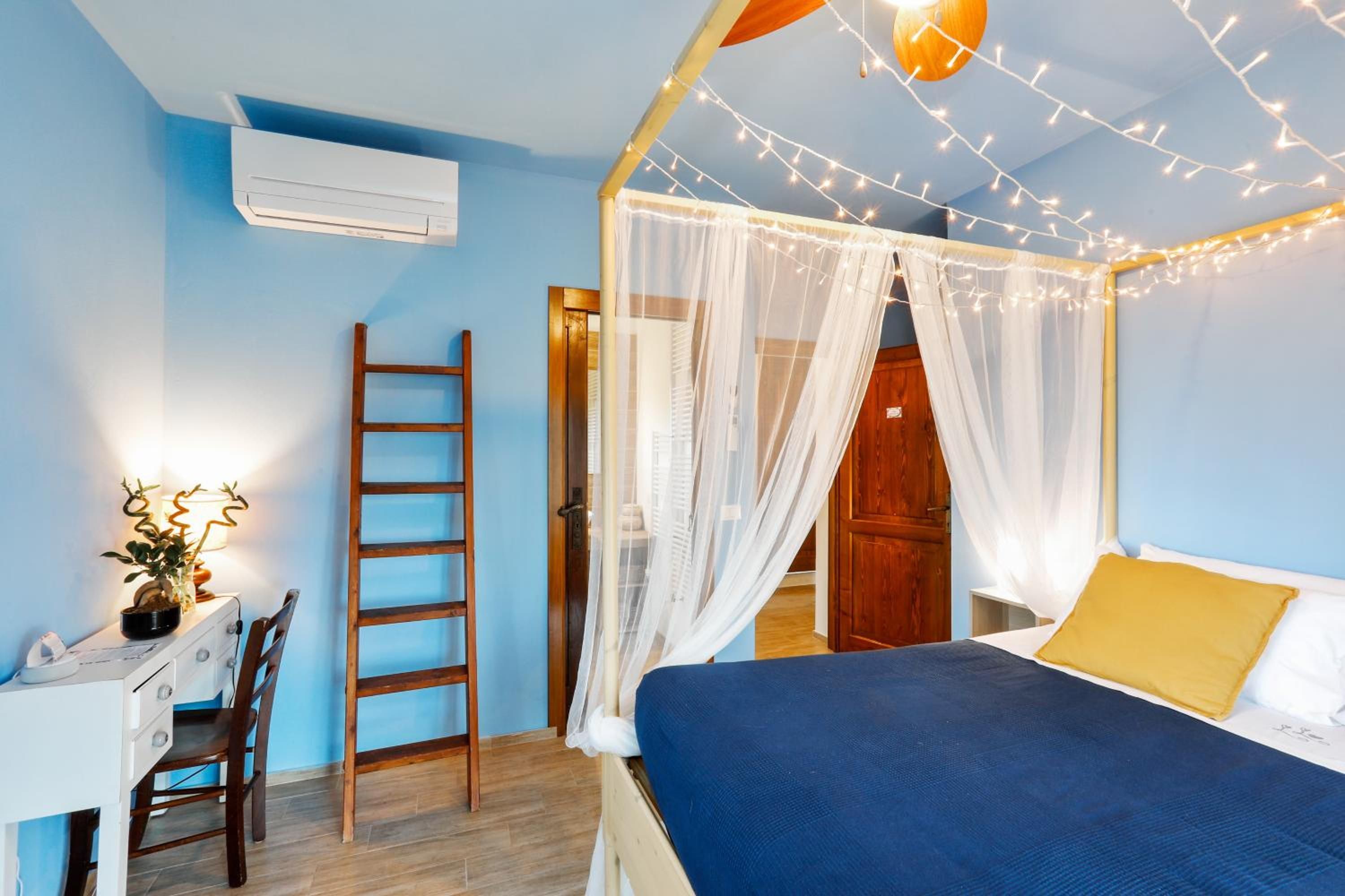 Une chambre à coucher avec un lit, un bureau, une chaise, une échelle et une porte.