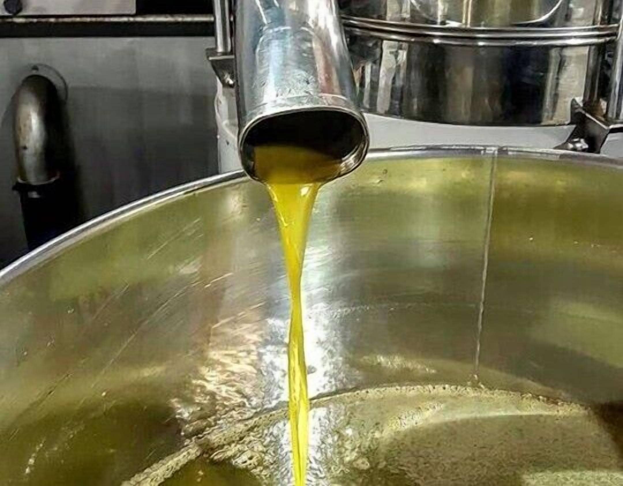 Un contenedor metálico grande con un líquido amarillento que se está vertiendo.