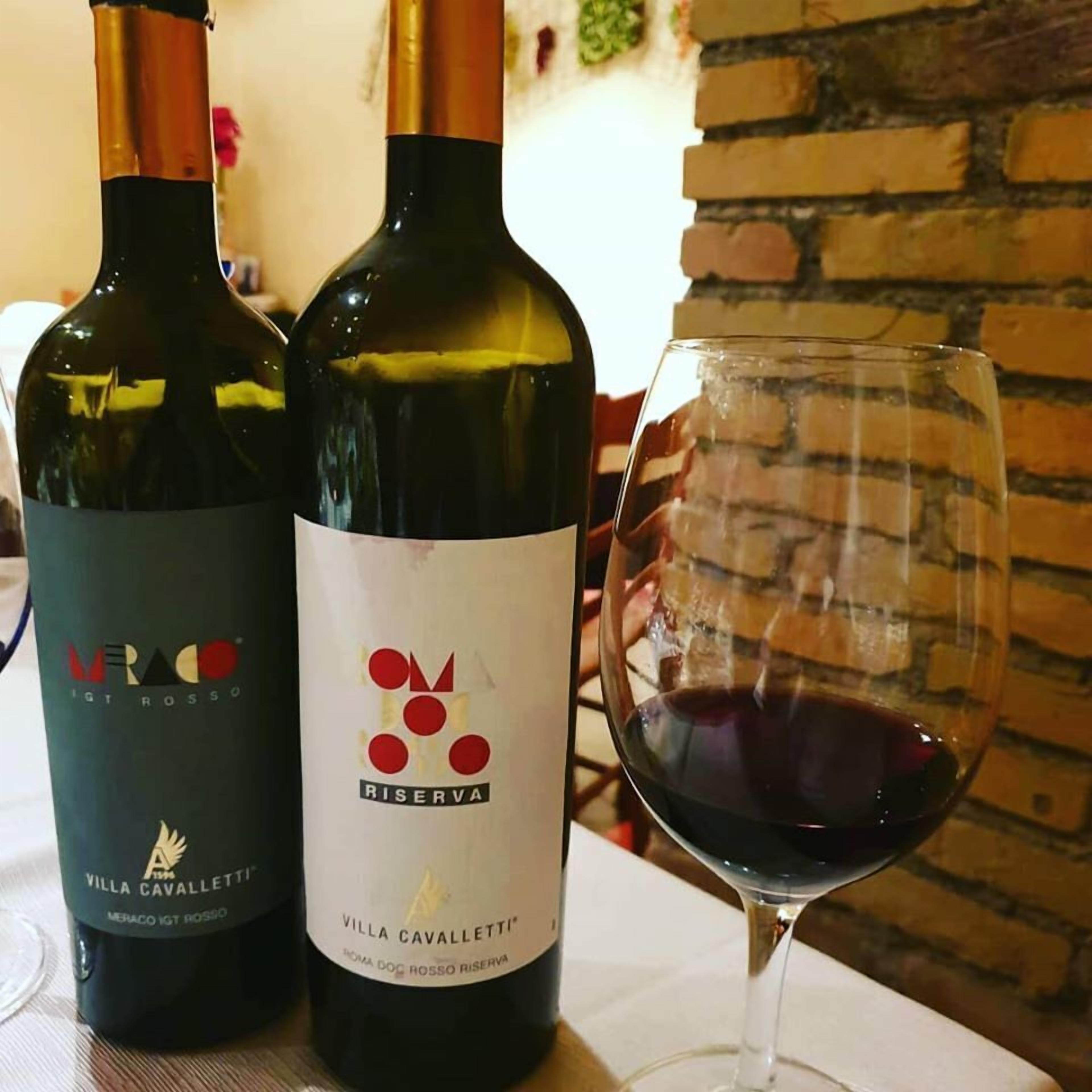 Dos botellas de vino y una copa sobre una mesa.