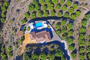 Luftaufnahme eines Resorts mit Schwimmbad, mehreren Gebäuden und umliegender Bepflanzung.