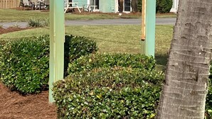 A sign for Sea Cabins at 1030, with a sailboat logo, in front of a building with balconies. - Cozy beach townhouse within walking distance to the beach. (Miramar Beach)