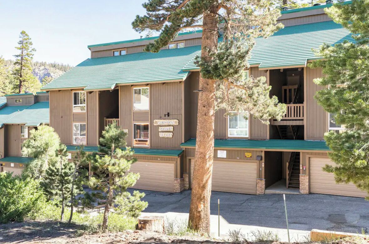 A building with multiple units, each featuring a balcony and a garage.