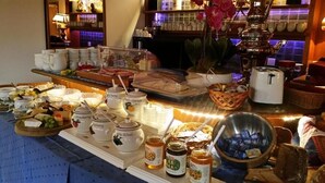 A buffet with various food items, including fruits, cheeses, and condiments. - Sportpension Christina (Fuegen)