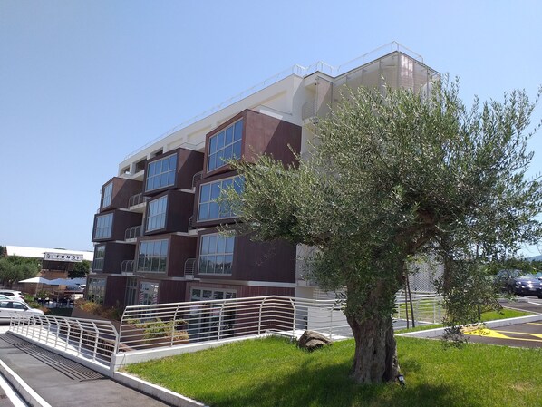 A multi-story building with a modern design, featuring large windows and a balcony.