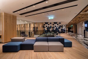 A modern lobby with a seating area, wooden panel walls, and a patterned floor. - Holiday Inn Express Chiayi by IHG (Chiayi City)