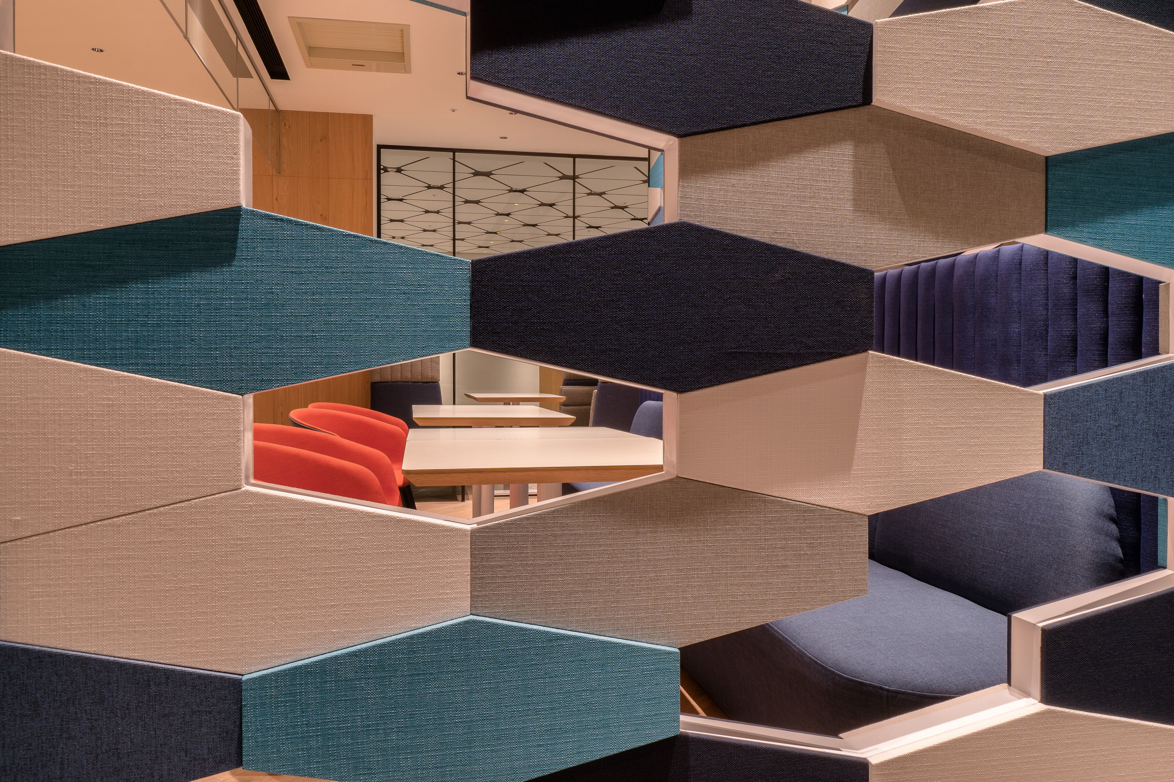 A modern interior with geometric partition walls and seating areas.
