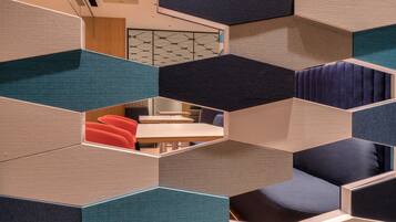 A modern interior with geometric partition walls and seating areas.
