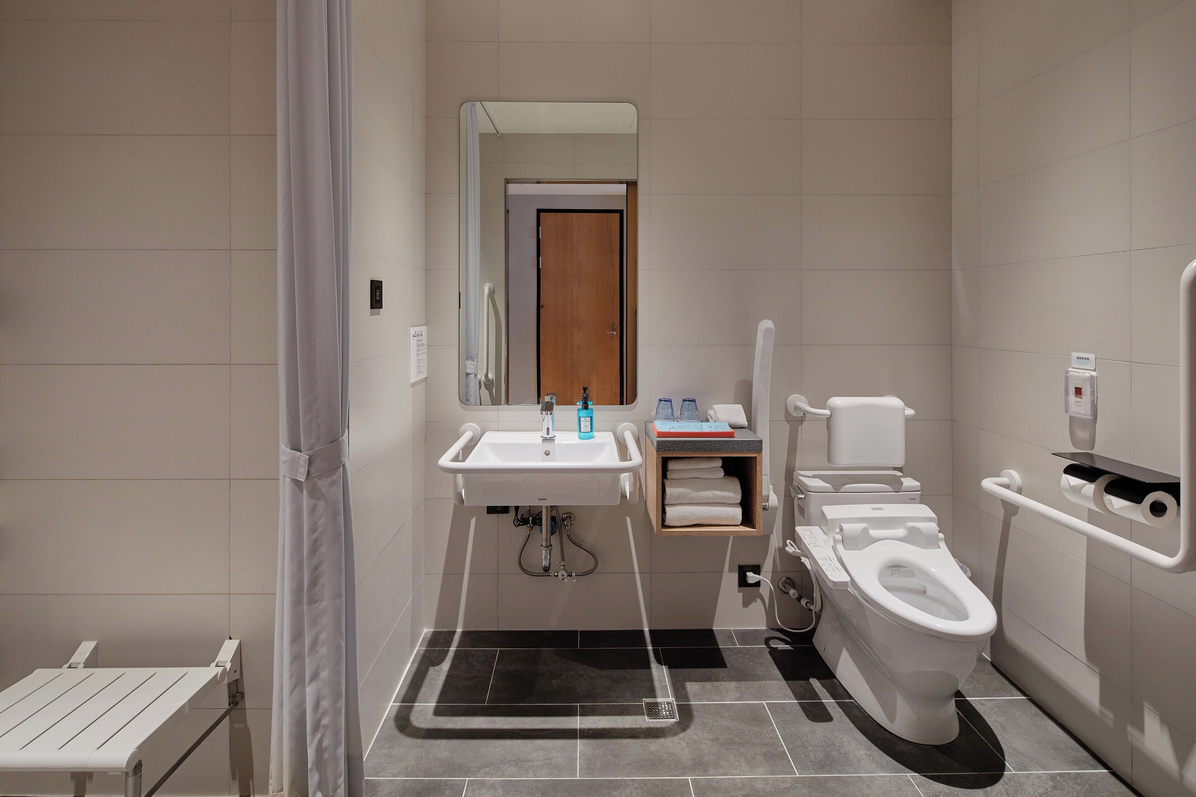 Une salle de bain moderne avec un lavabo, des toilettes et une douche, le tout de couleur blanche.