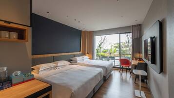 Standaard kamer, 1 kingsize bed met slaapbank, uitzicht op tuin | Donsdekens, een kluis op de kamer, een bureau, een laptopwerkplek