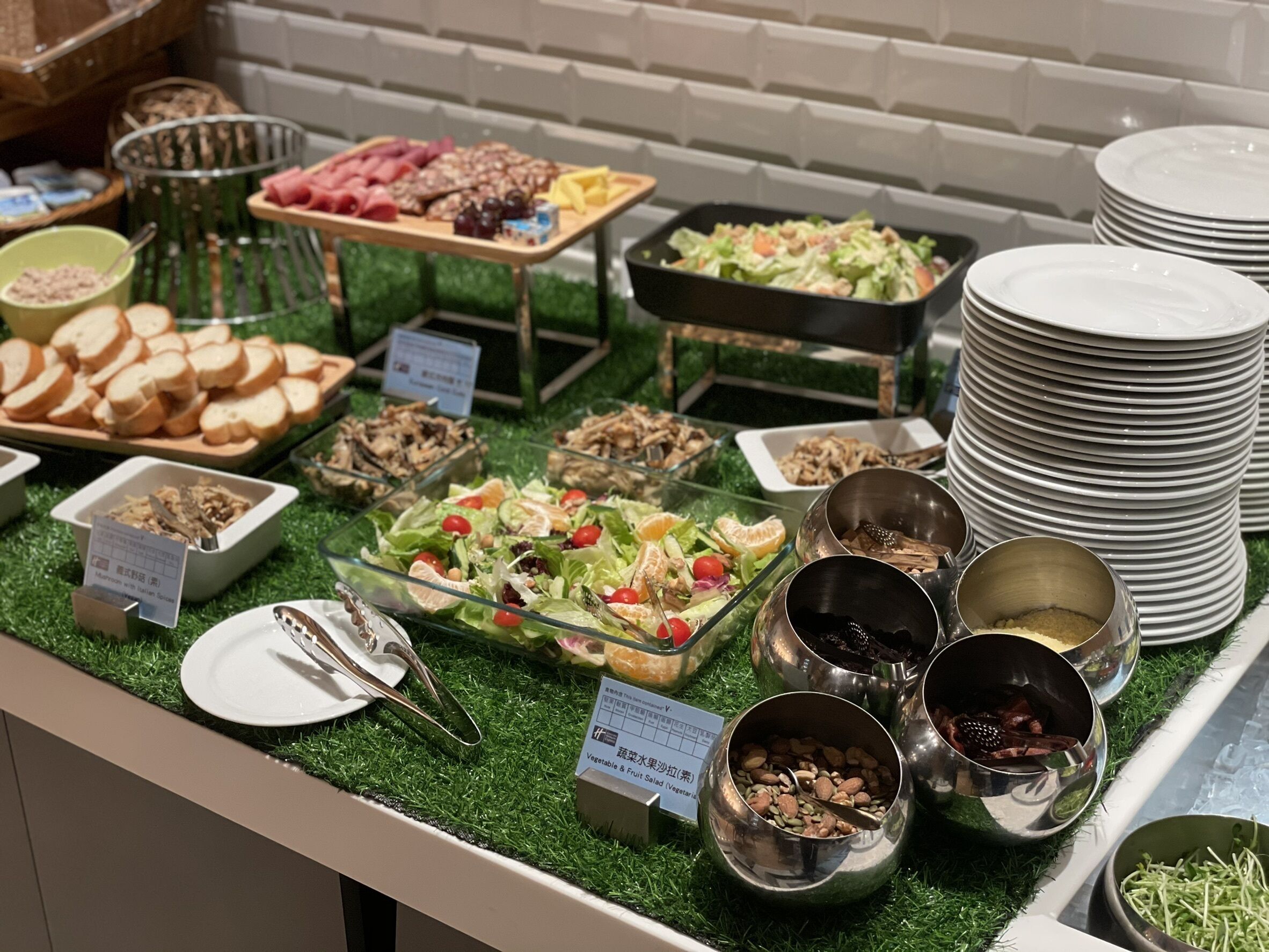 A buffet with various food options including salads, fruits, and nuts.