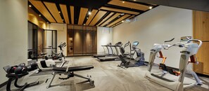 Une salle de sport équipée de tapis de course, de vélos d’appartement et d’appareils de musculation.