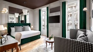 A hotel room with a large bed, a sofa, a small table, and a TV. - Matilde Boutique Hotel, WorldHotels Elite (Milan)