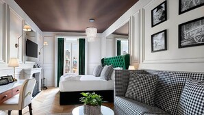 A modern bedroom with a bed, a checkered sofa, a desk, and a TV. - Matilde Boutique Hotel, WorldHotels Elite (Milan)