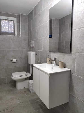 Habitación doble, vistas al patio, planta baja | Baño | Ducha, secador de pelo, bidé y toallas