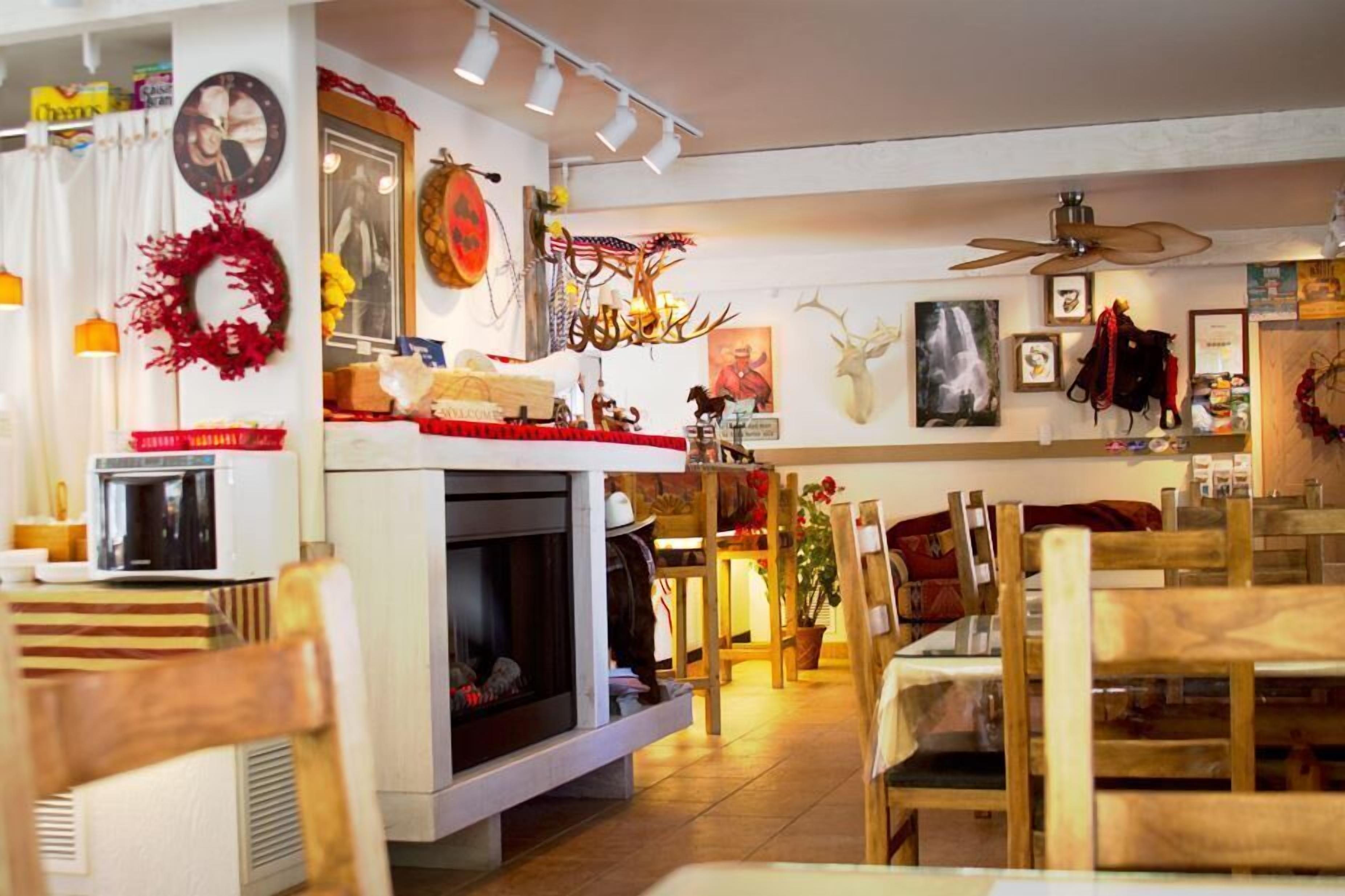 A cozy restaurant interior with a fireplace, wooden tables, and various decorations including antlers and a deer head.