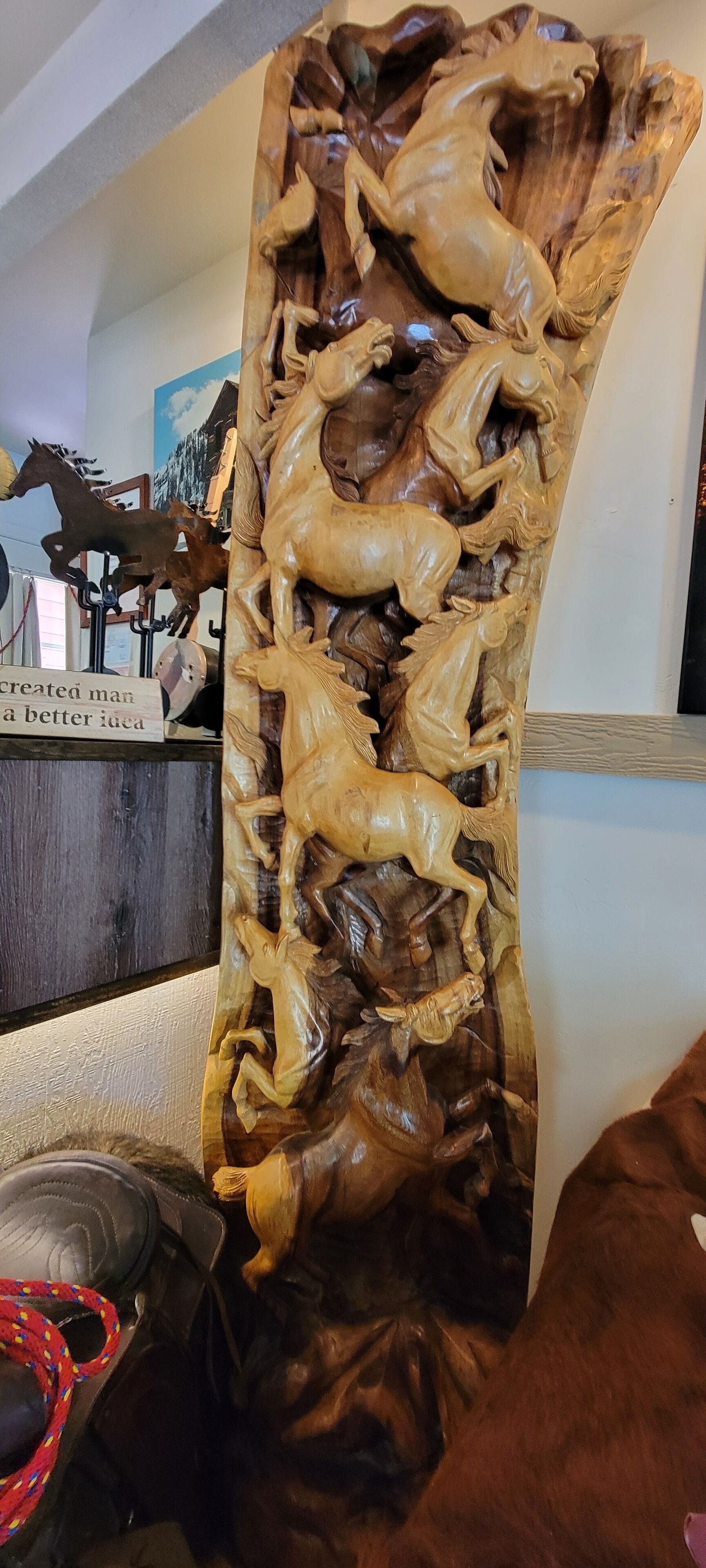 Une grande sculpture en bois représentant des chevaux et des cavaliers.