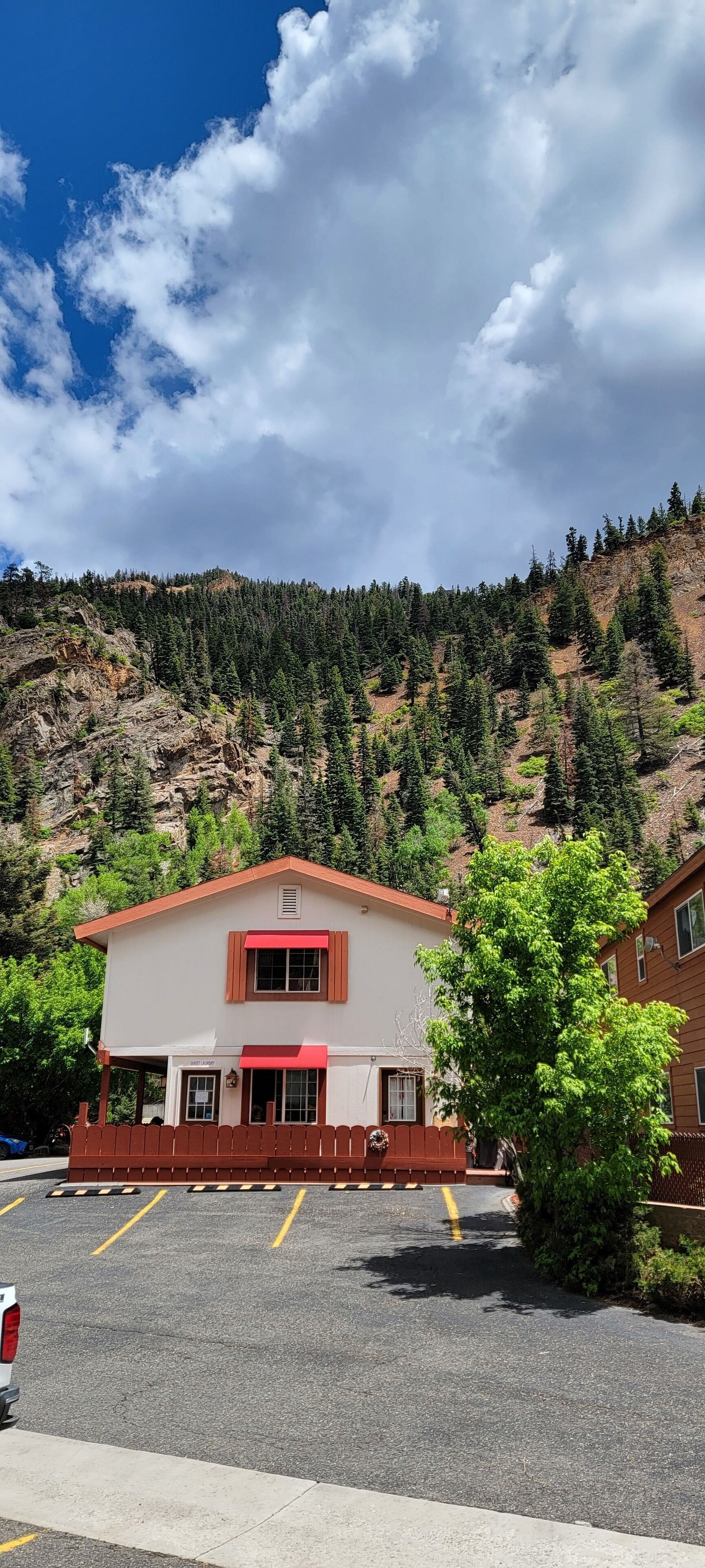 Un bâtiment avec un auvent rouge et une enseigne indiquant « Café Restaurant ».