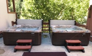 Two hot tubs with wooden steps and a view of trees. - Hot Springs Inn (Ouray)