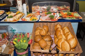 Une table de buffet avec divers plats et un panier de pain.