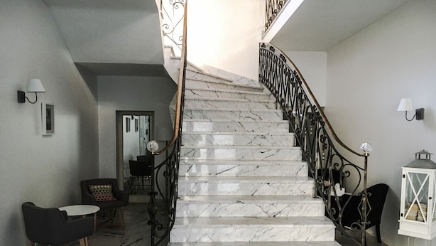 A marble staircase with a curved design, leading to an upper floor.