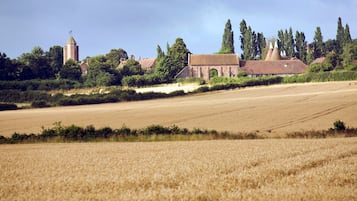 Ländliche Landschaft mit Feld, Kirche und Turm.