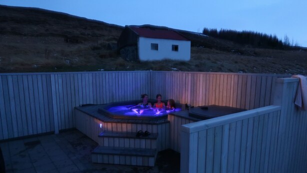 A wooden deck with a hot tub and steps leading up to it. - Original North Country House (Laugar)