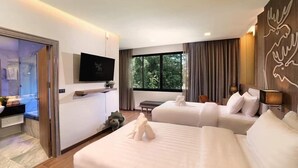 Ein modernes Hotelzimmer mit zwei Betten, einem Fernseher, einem Schreibtisch und einem großen Fenster mit Vorhängen.