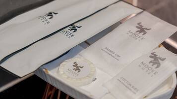 A travel package with a moose logo, including a shower cap and cotton swab.